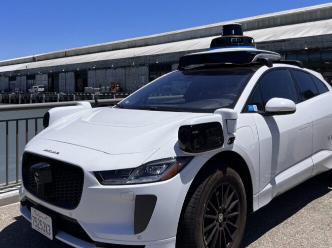 A white Waymo (self-driving car) park on the pier.